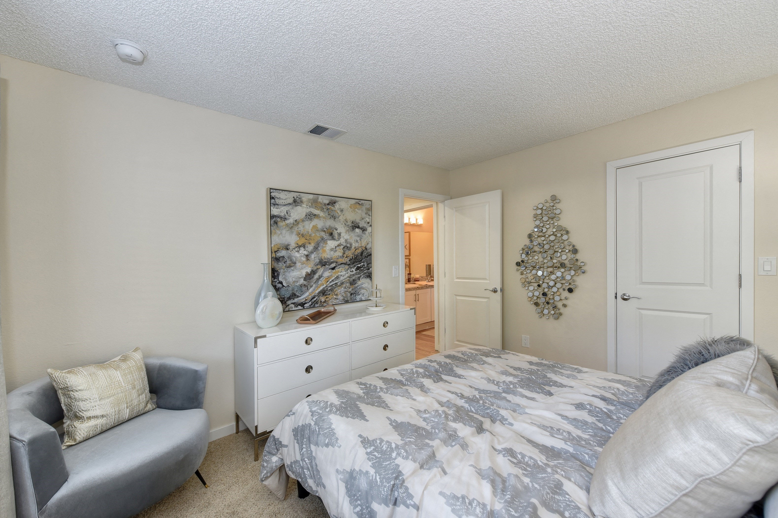 Bedroom with Attached Bath, Carpet, White Dresser and Gray Chair